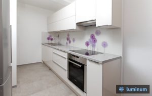 Vijolične regratove lučke na kuhinjskem steklu v beli kuhinji