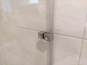 Detajl pritrdilnega elementa na stekleni tuš kabini Luminum iz kaljenega stekla po meri